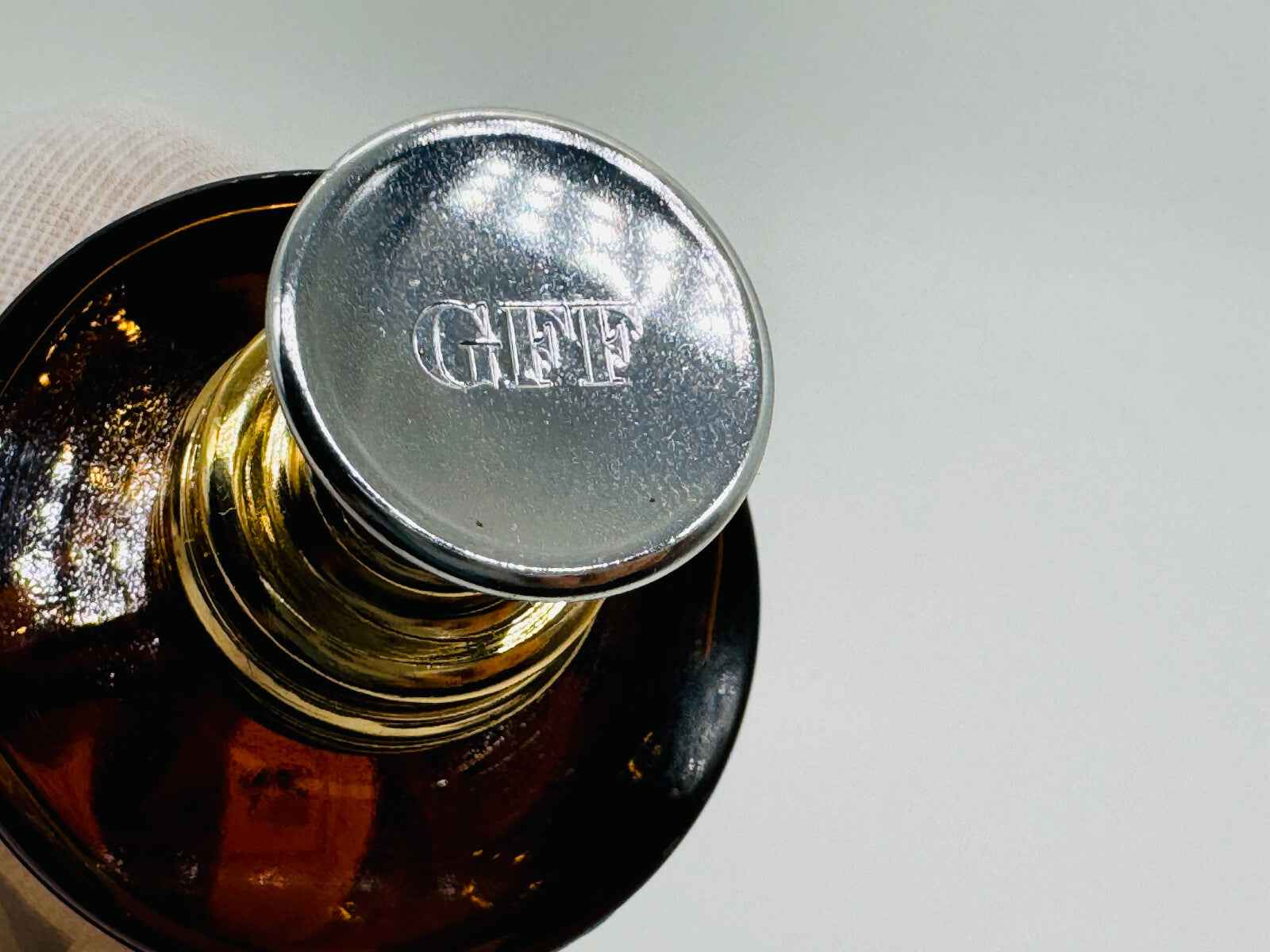 Dettaglio del tappo di un profumo Gff Uomo Vintage con logo inciso in metallo lucido