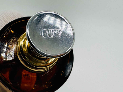 Dettaglio del tappo di un profumo Gff Uomo Vintage con logo inciso in metallo lucido