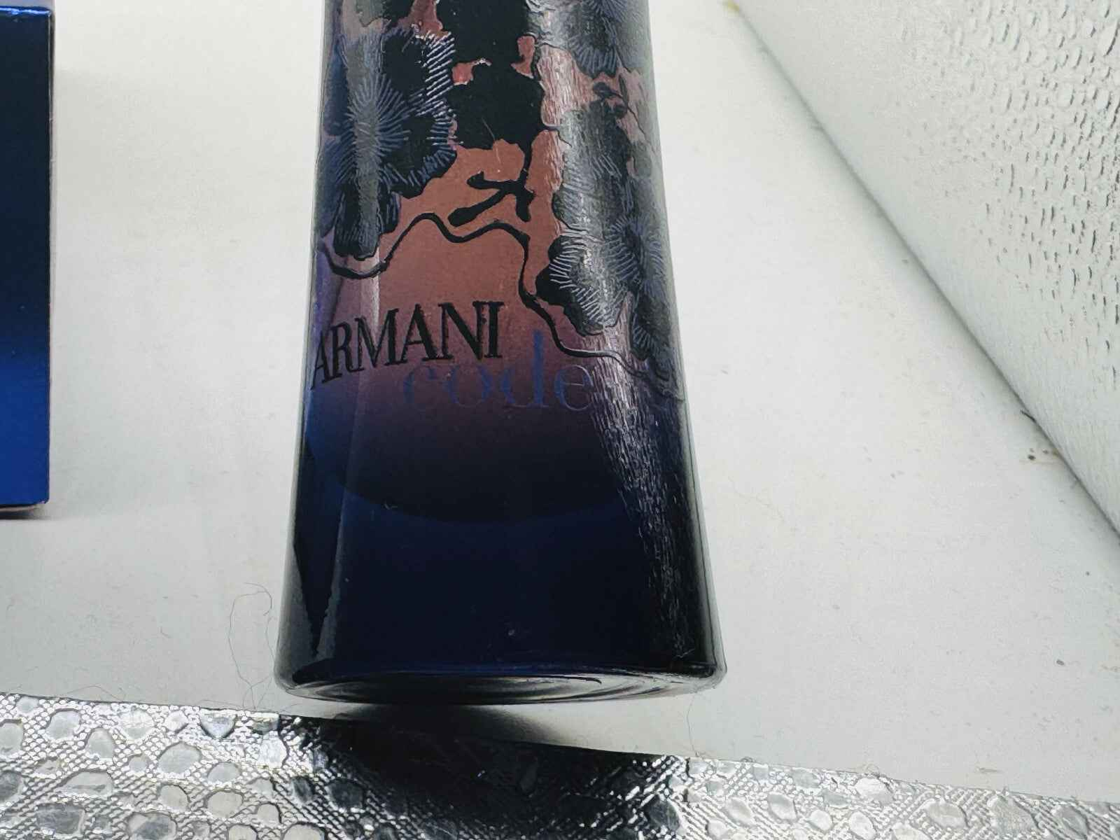 Flacone di Profumo Armani Code Elixir con design elegante e dettagli floreali in blu scuro