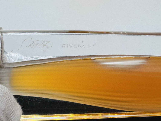 Bottiglia di profumo Givenchy Organza Vintage con eleganti curve e tonalità calde di ambra