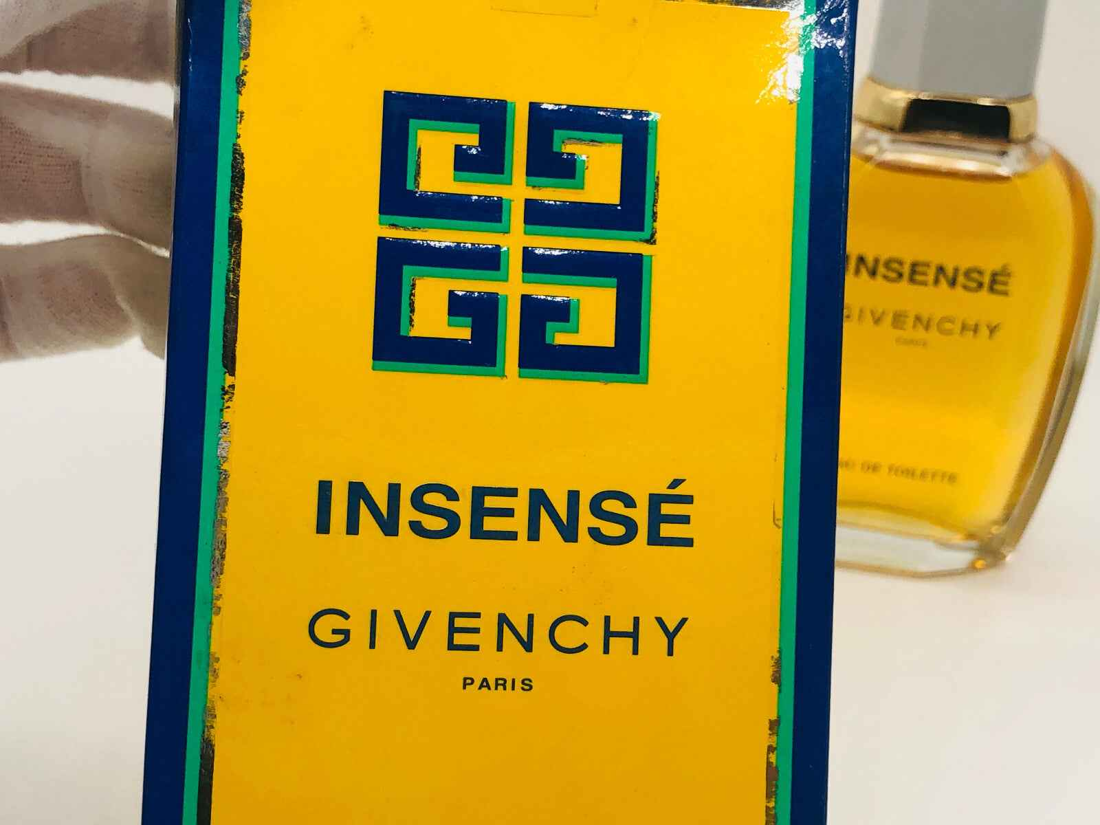 Confezione di profumo Givenchy Insense Vintage con design vivace e flacone elegante sullo sfondo