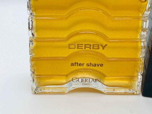 Dopo barba Derby Guerlain in bottiglia trasparente con liquido giallo brillante