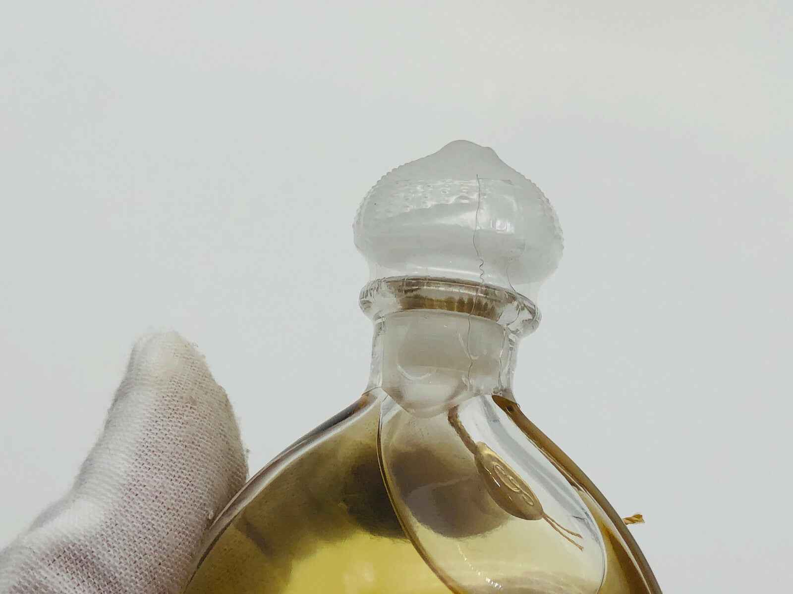 Dettaglio di flacone di profumo Guerlain Mitsouko Vintage con tappo decorativo in vetro