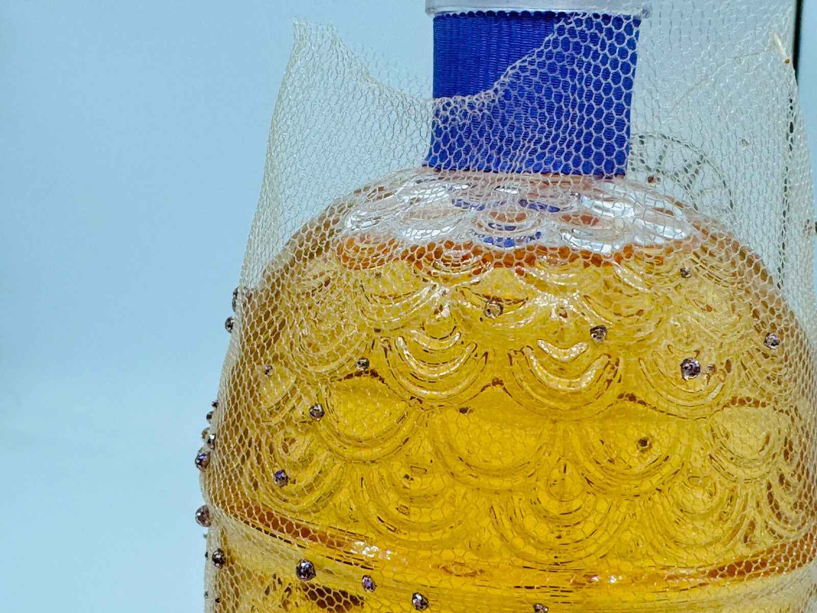 Flacone di profumo Guerlain L'Instant Vintage con dettagli decorativi e tonalità dorata