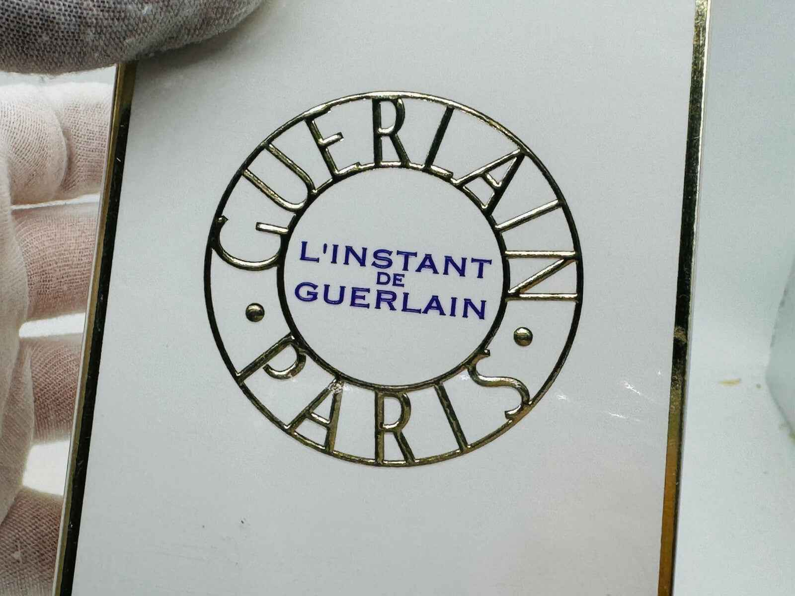 Logo del profumo Guerlain L'Instant Vintage su una boccetta elegante con dettagli dorati