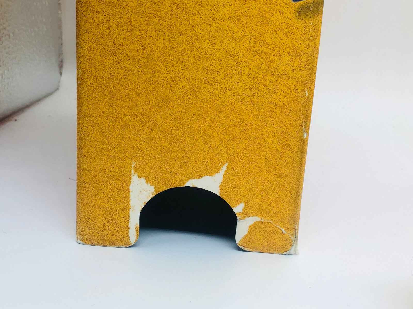 Scatola vintage profumo Hermes Rocabar con segni di usura su fondo giallo