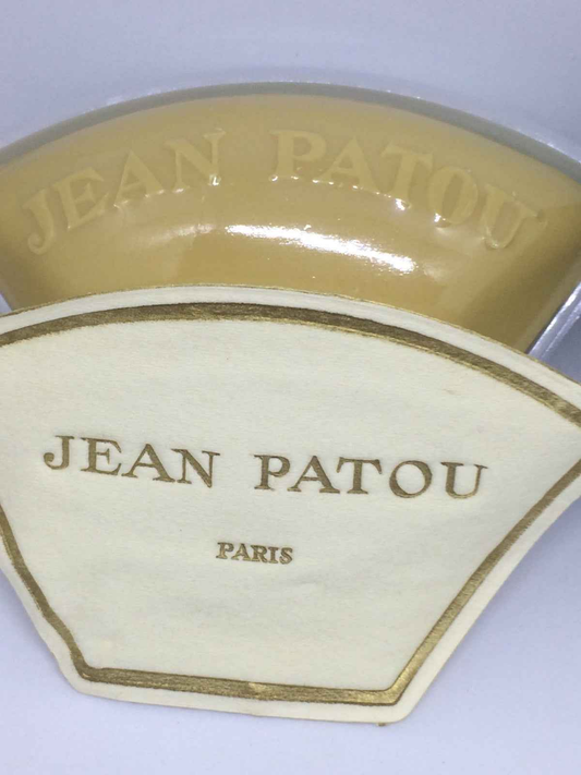 Packaging del profumo Jean Patou Lacoste Pour Homme in una forma distintiva con logo dorato