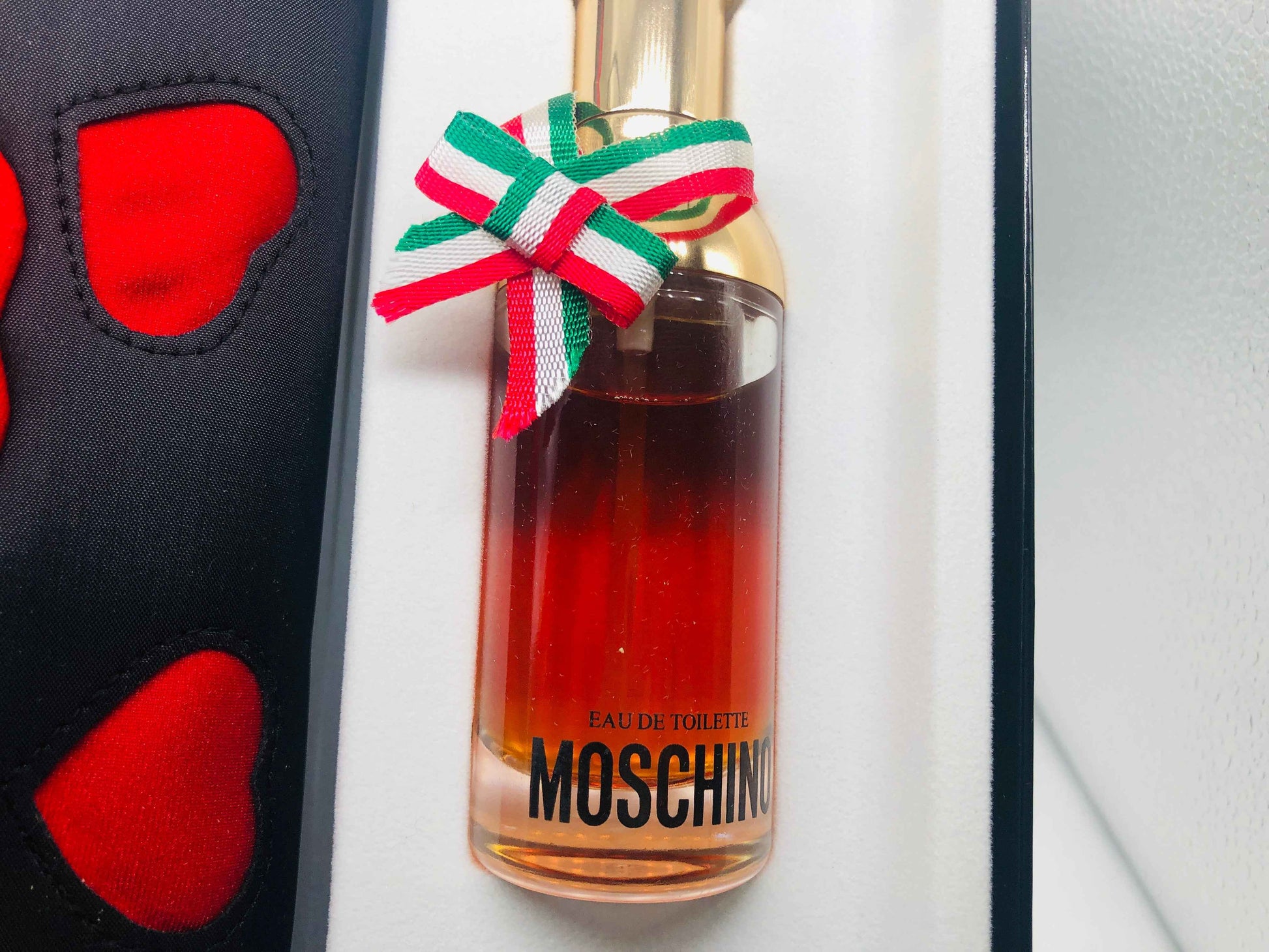 Profumo Moschino Donna in bottiglia elegante con nastro tricolore, ideale per occasioni speciali