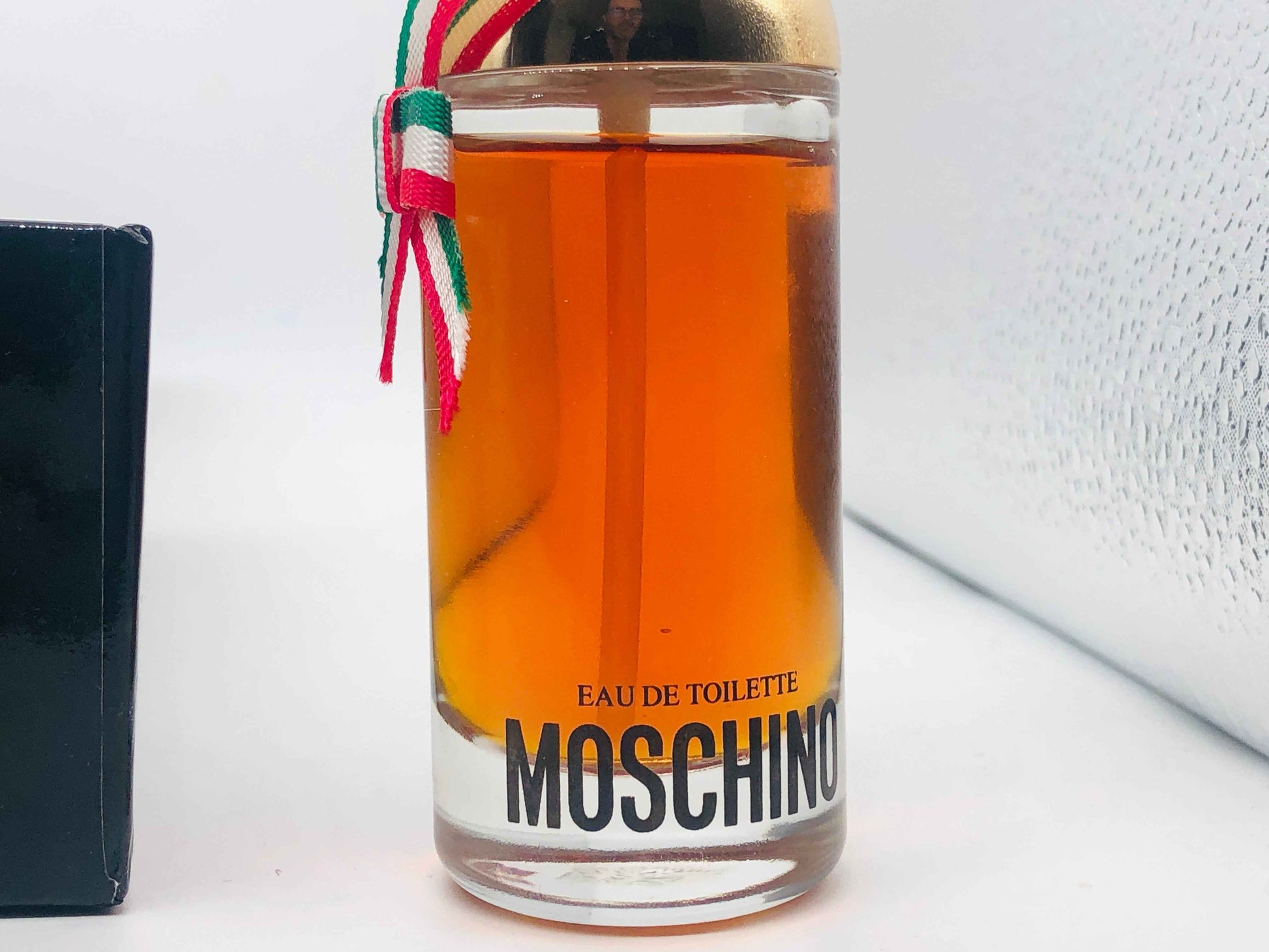 Flacone di profumo Moschino Donna in vetro trasparente con tappo dorato e nastro tricolore