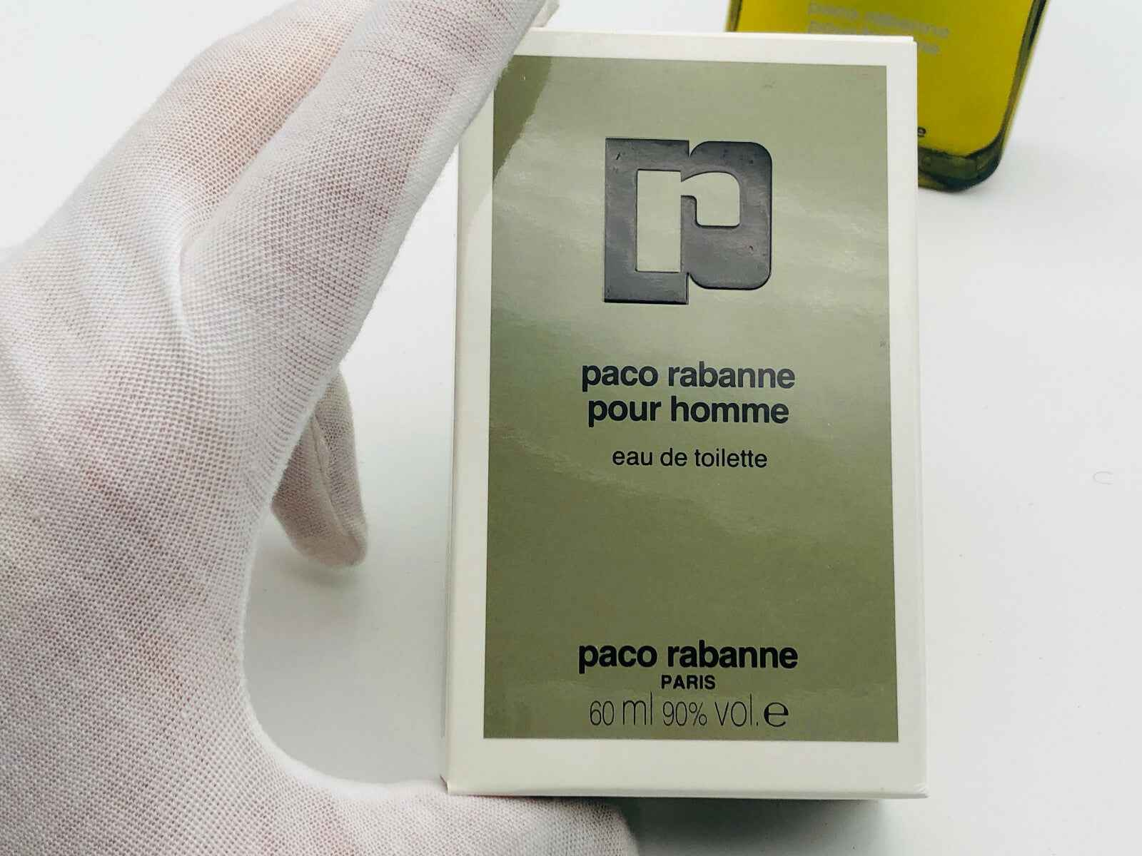 Scatola di profumo Paco Rabanne Vintage pour homme 60 ml in una mano con guanto bianco