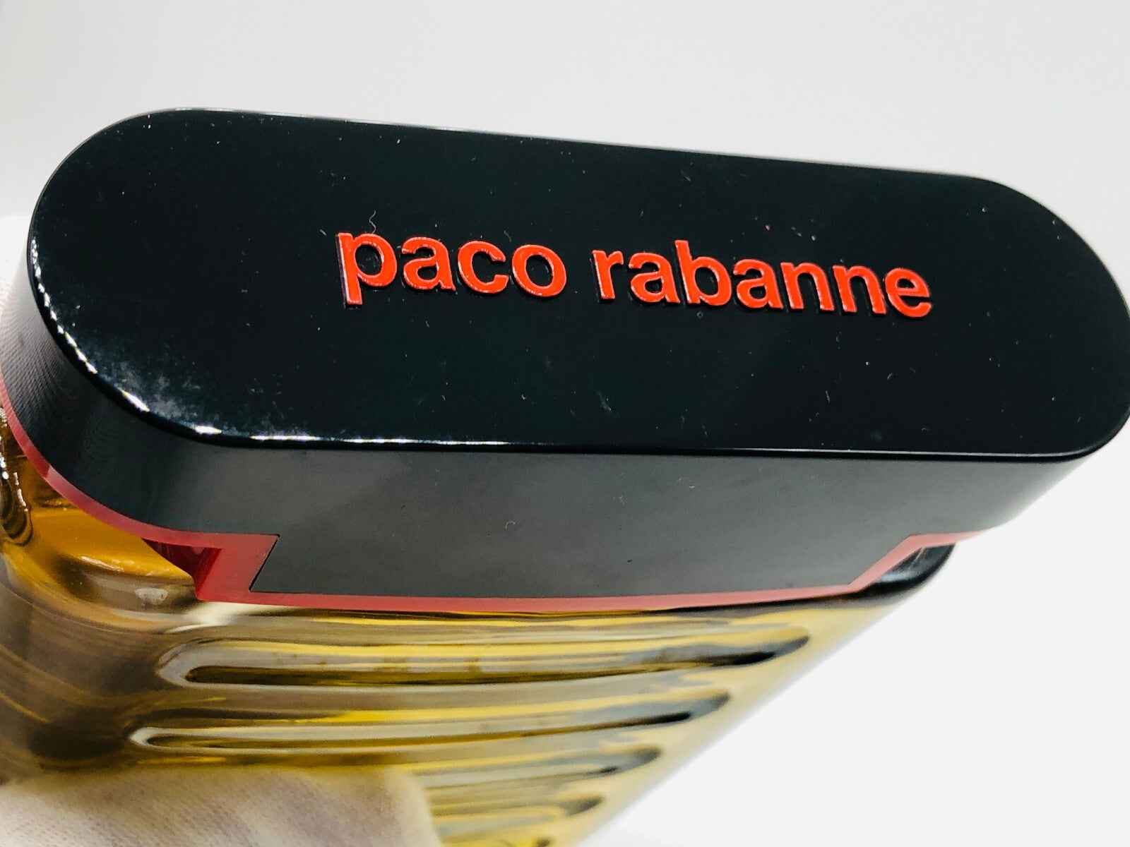 Dettaglio del tappo del profumo Tenere Paco Rabanne con design elegante e logo distintivo