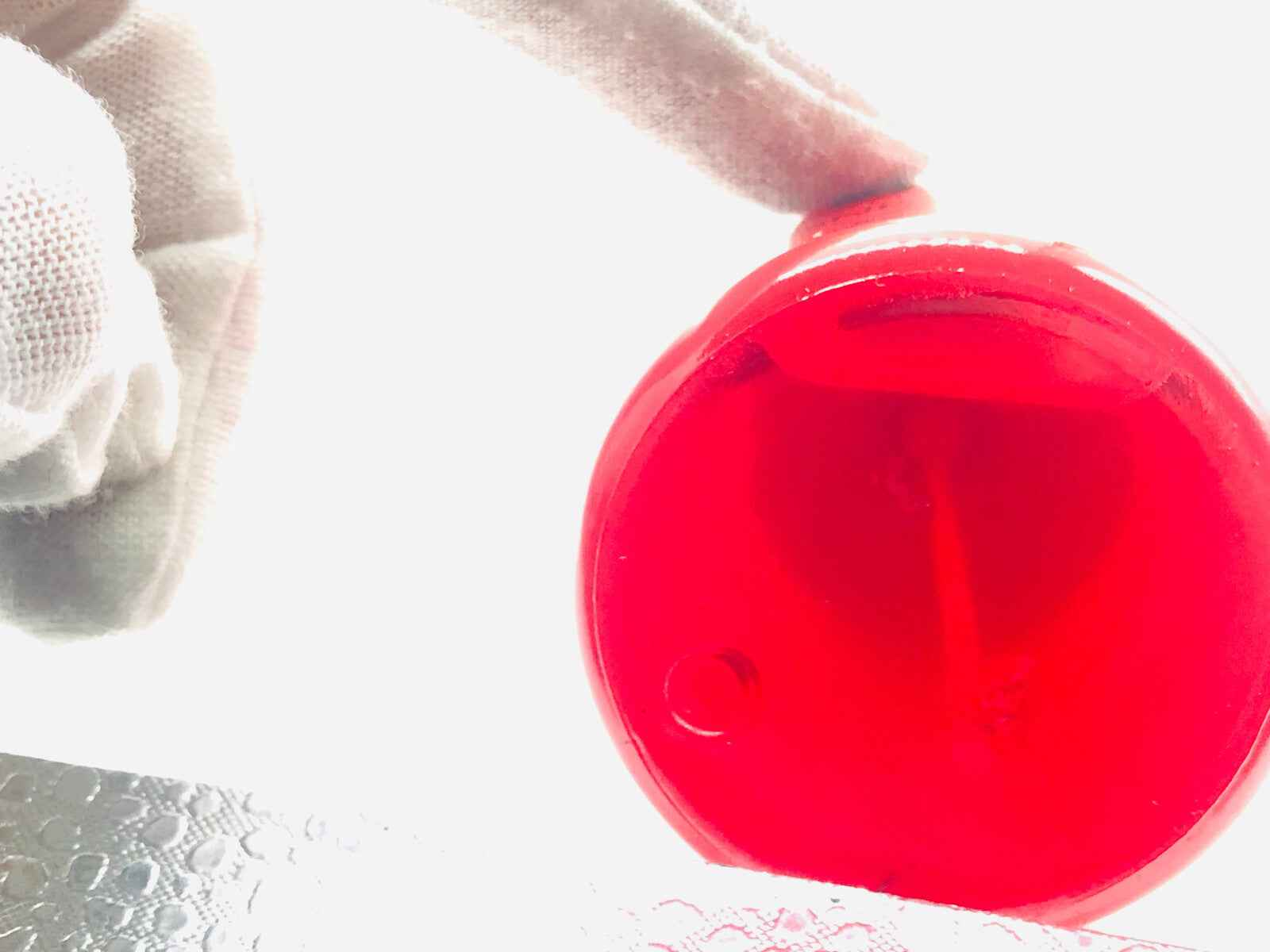 Dettaglio del fondo della bottiglia di Profumo Adam Cologne Vintage con design rosso e elegante
