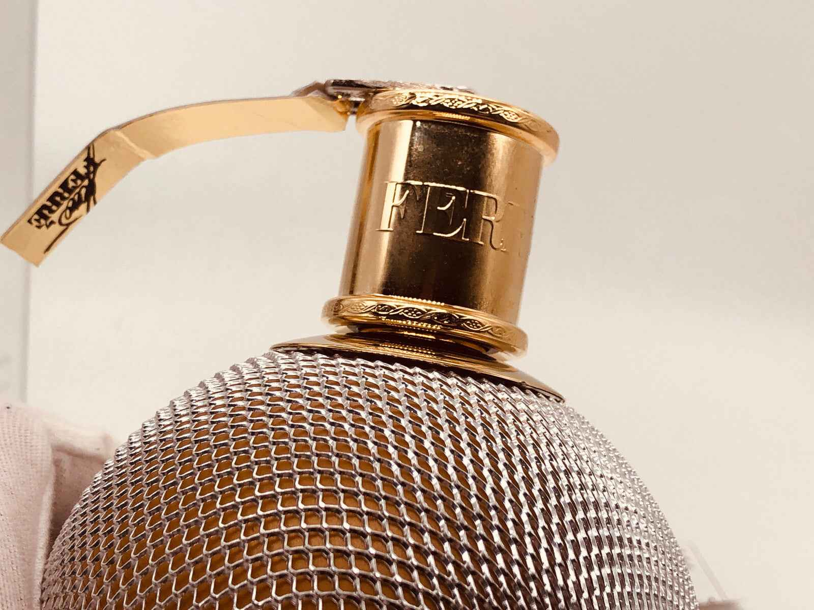 Flacone di profumo Ferre Vintage con tappo dorato e design elegante in rete metallica