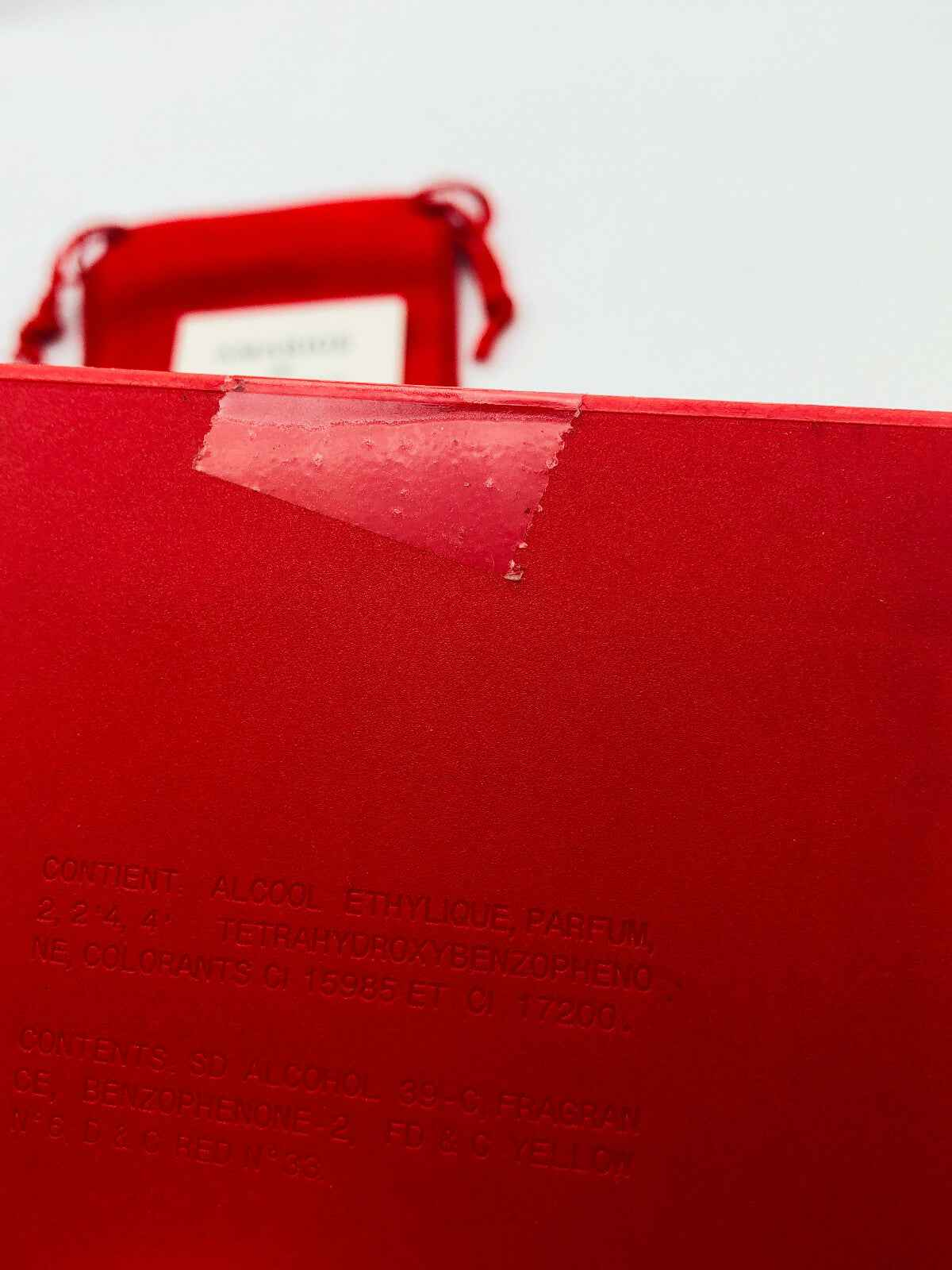 Scatola rossa del profumo Givenchy Amarige con dettagli del contenuto e la scritta in rilievo