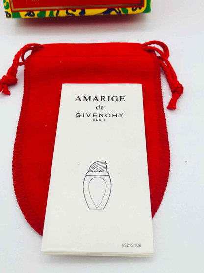 Campione di profumo Givenchy Amarige con packaging elegante su sfondo rosso