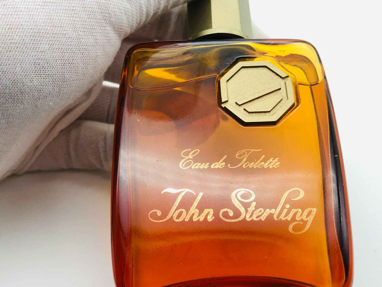 Profumo John Sterling in flacone elegante con etichetta dorata e tonalità di ambra