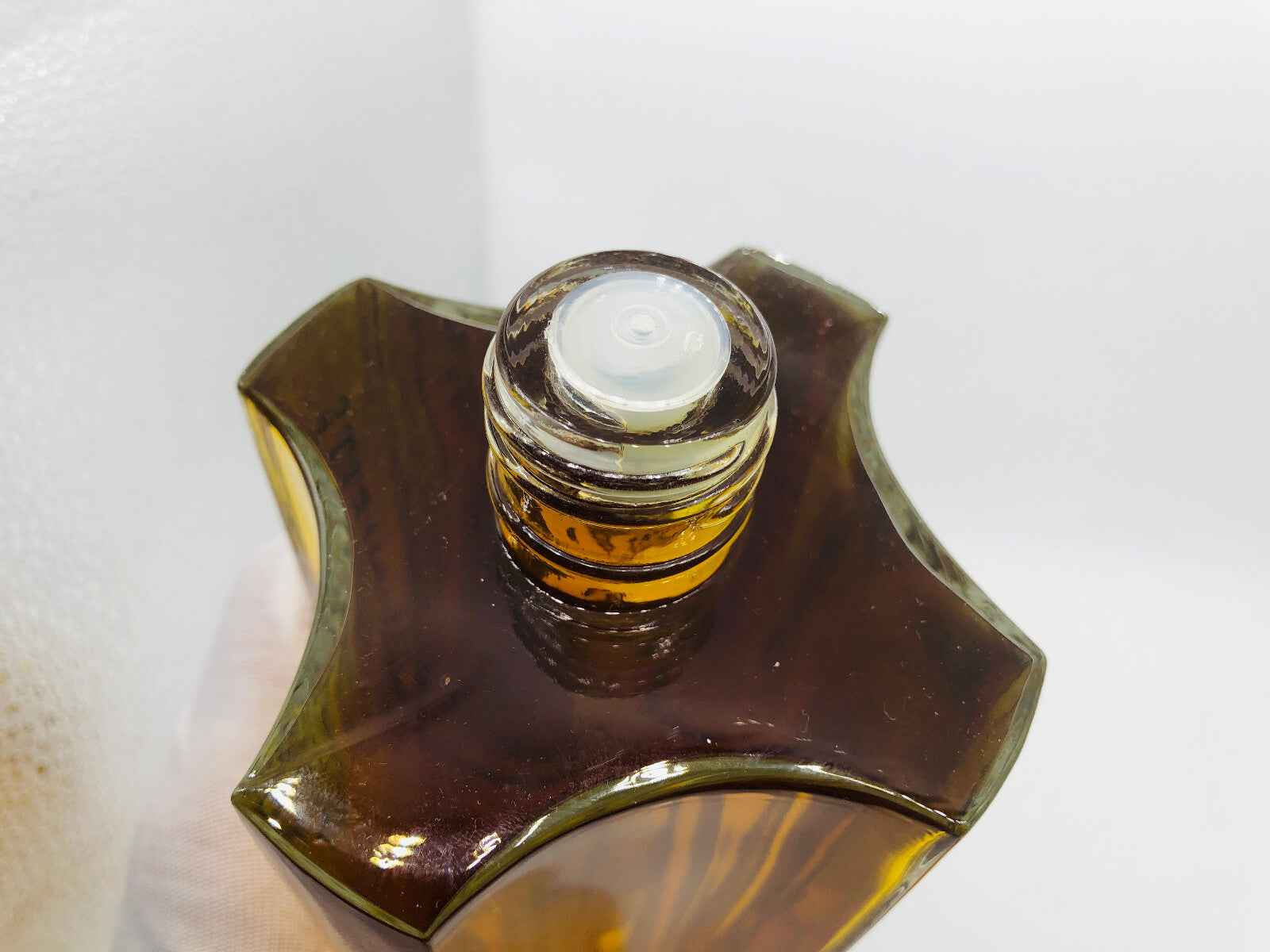 Dettaglio del tappo di un flacone di profumo Monsieur Worth con design elegante e raffinato