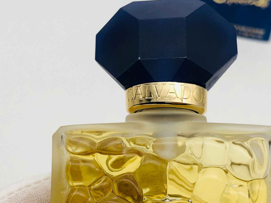 Dettaglio del flacone di profumo Salvador Dali con tappo ottagonale nero e design elegante