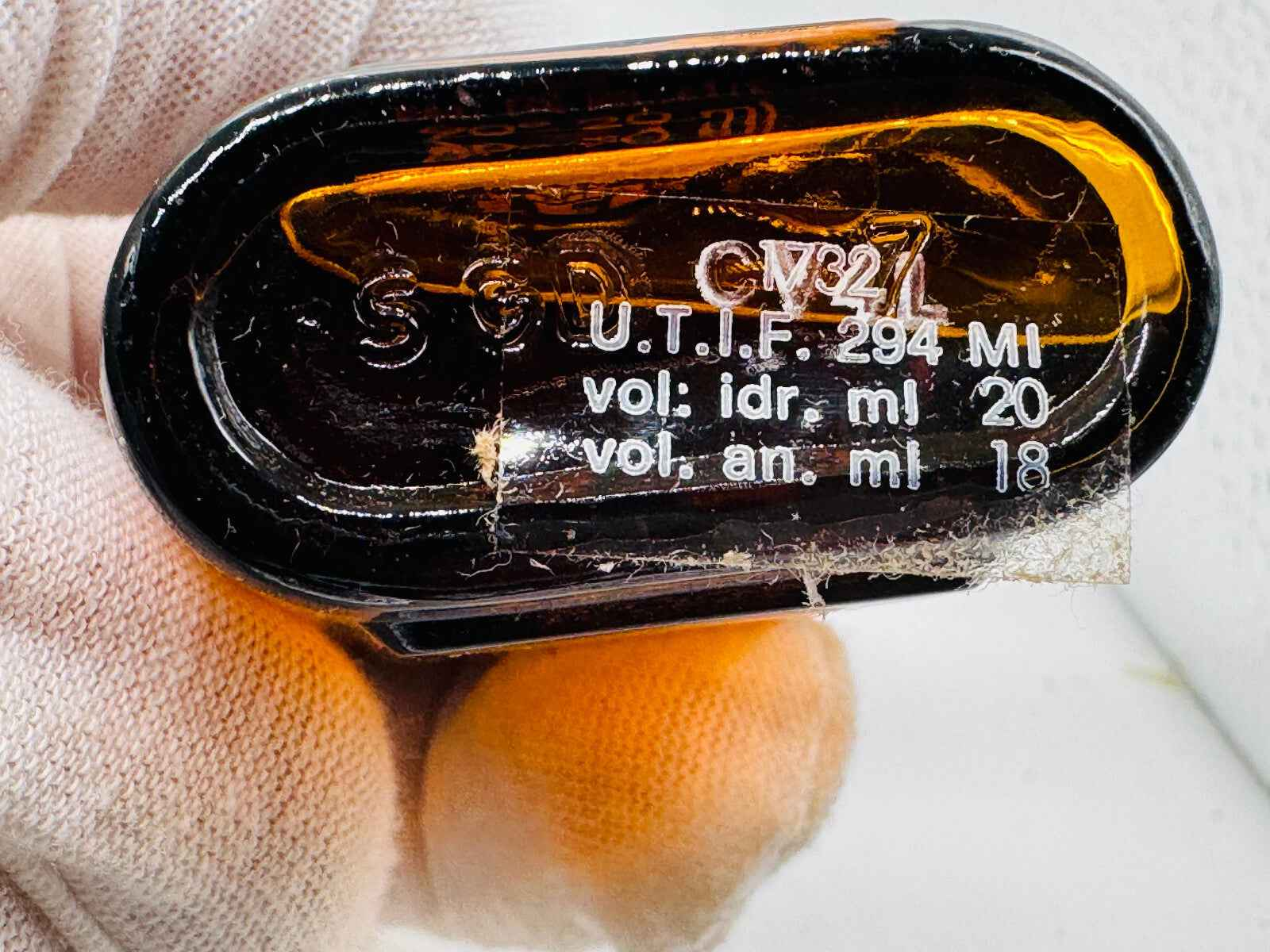 Dettaglio sul fondo del flacone di profumo Ted Lapidus Pour Homme con indicazioni sul volume
