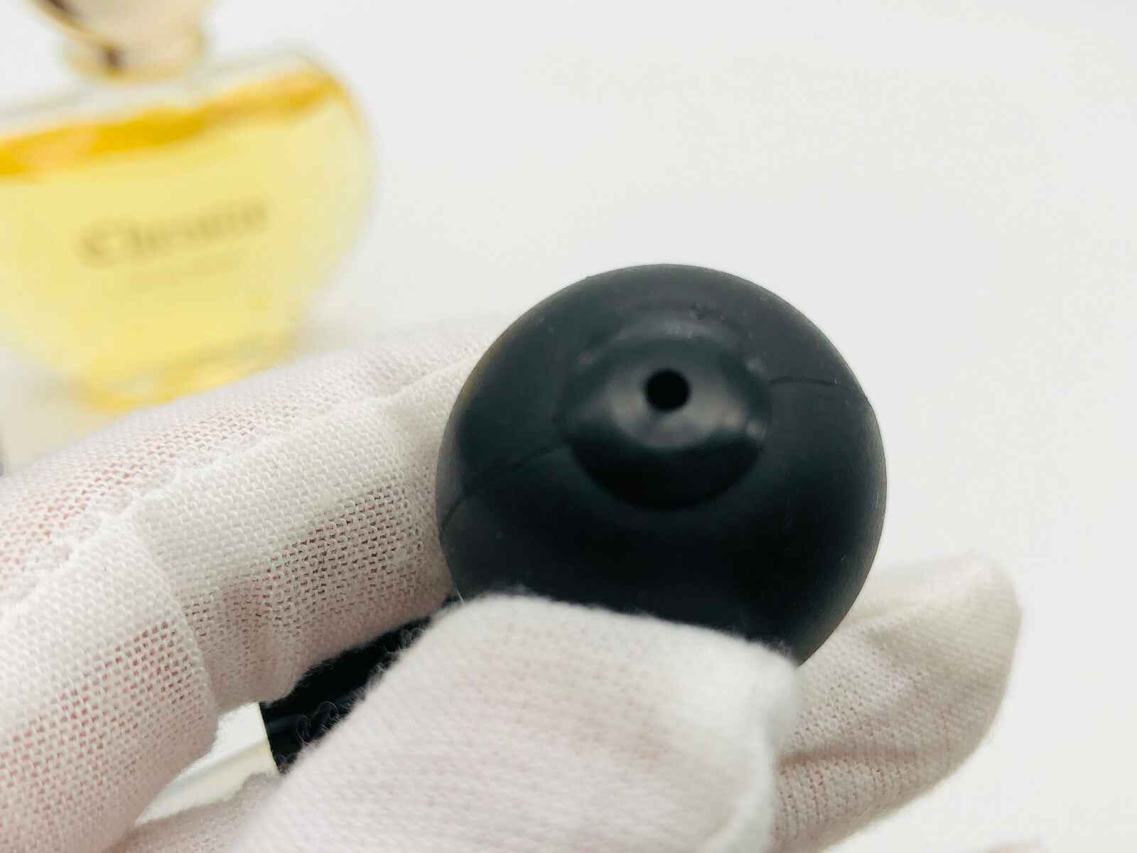 Flacone di profumo Veejaga Christie con tappo nero in primo piano su sfondo sfocato