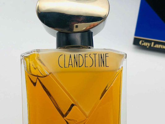 Flacone di profumo vintage Clandestine Laroche con design elegante e liquido dorato