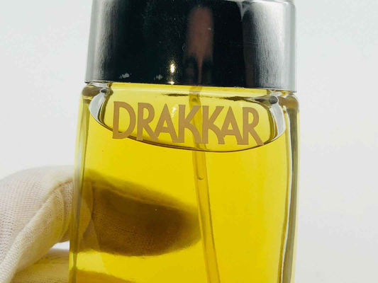 Flacone di profumo vintage Drakkar Guy Laroche con design elegante e liquido dorato
