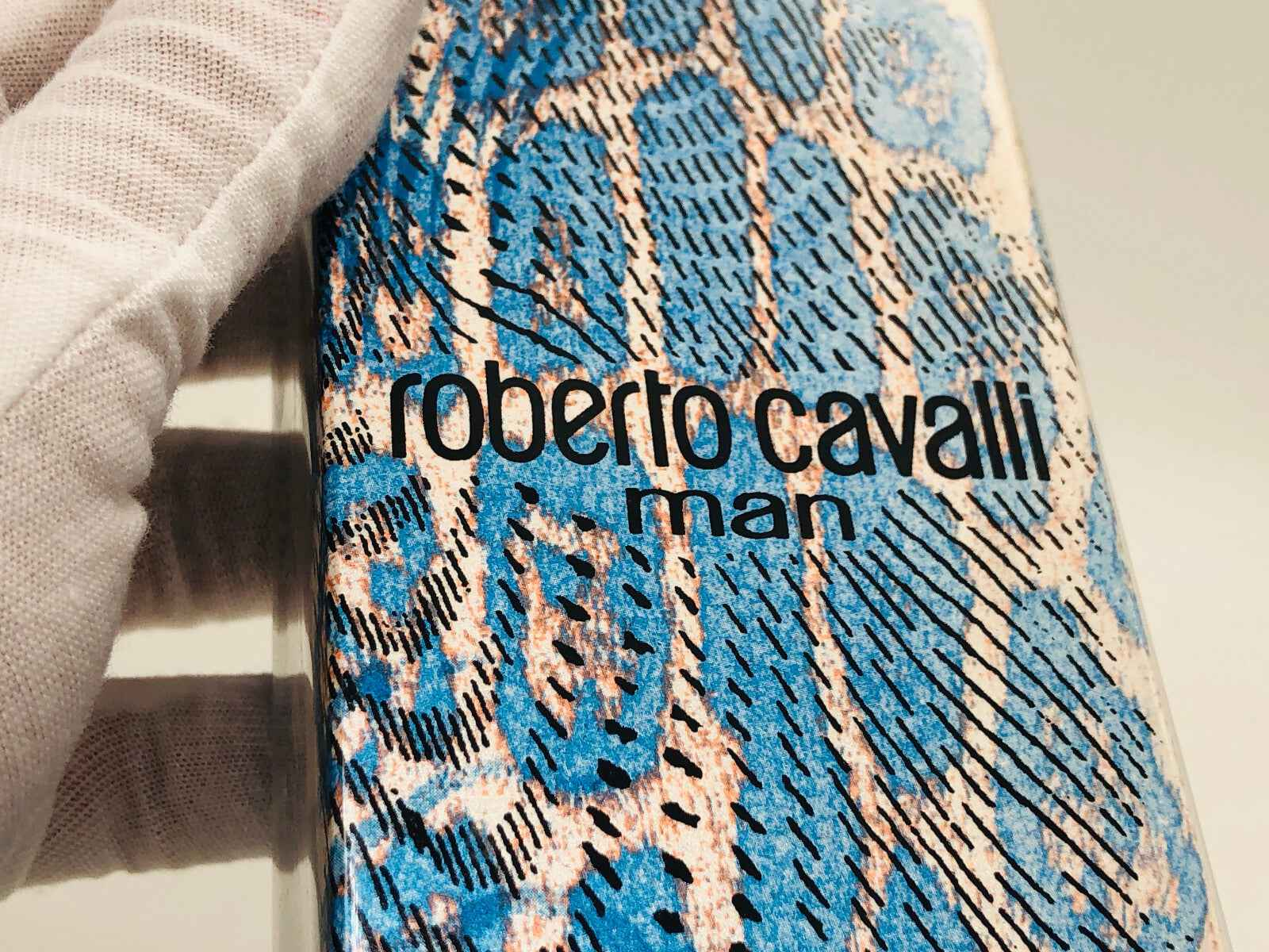 Flacone di profumo roberto cavalli man con design in pelle di serpente blu e beige