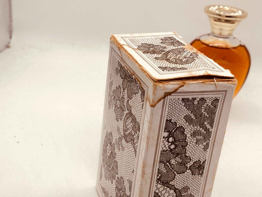 Scatola vintage di Rochas Femme con dettagli floreali e profumo sullo sfondo