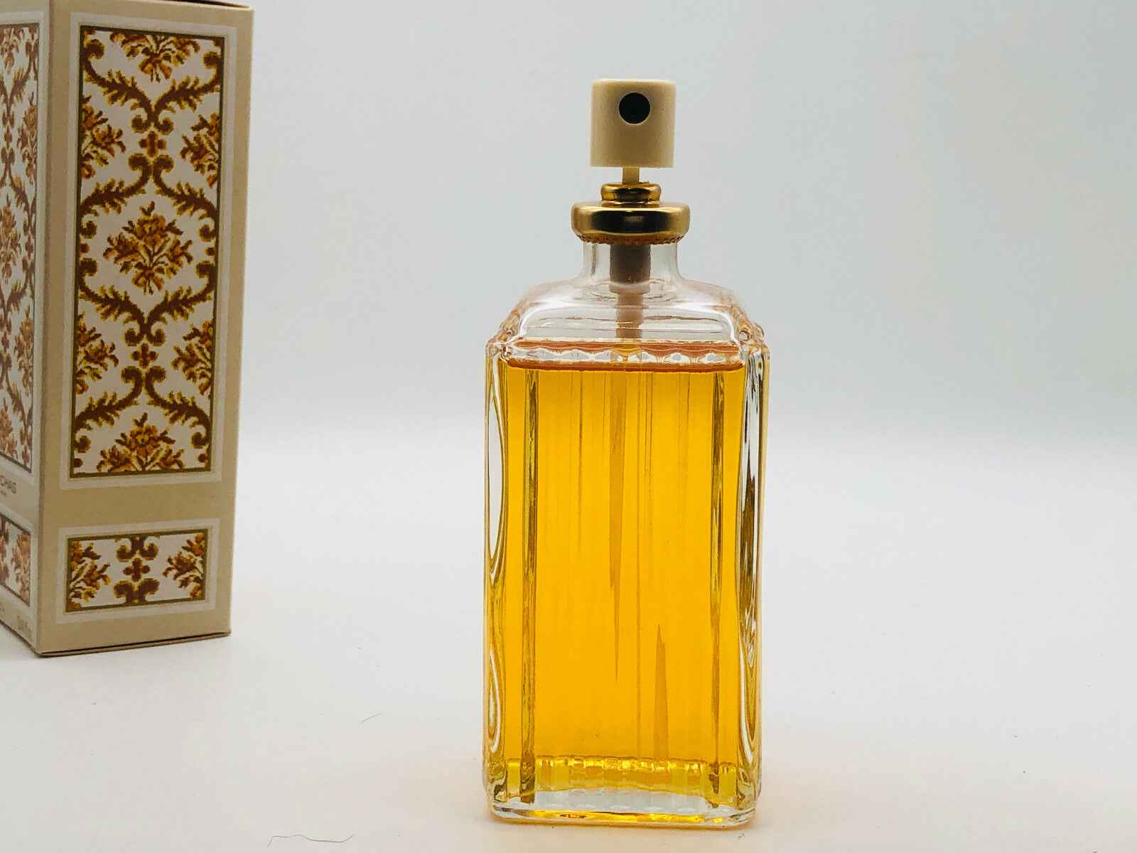 Flacone di profumo Rochas Madame Vintage con liquido dorato e tappo elegante