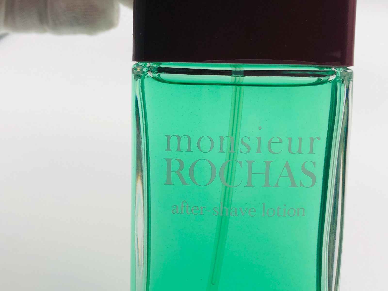 Flacone di lozione dopobarba Rochas Monsieur Pour Homme con tappo marrone e liquido verde