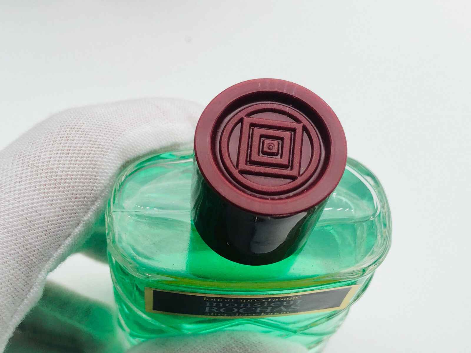 Dettaglio del tappo del profumo Rochas Monsieur Vintage con design elegante e colori distintivi