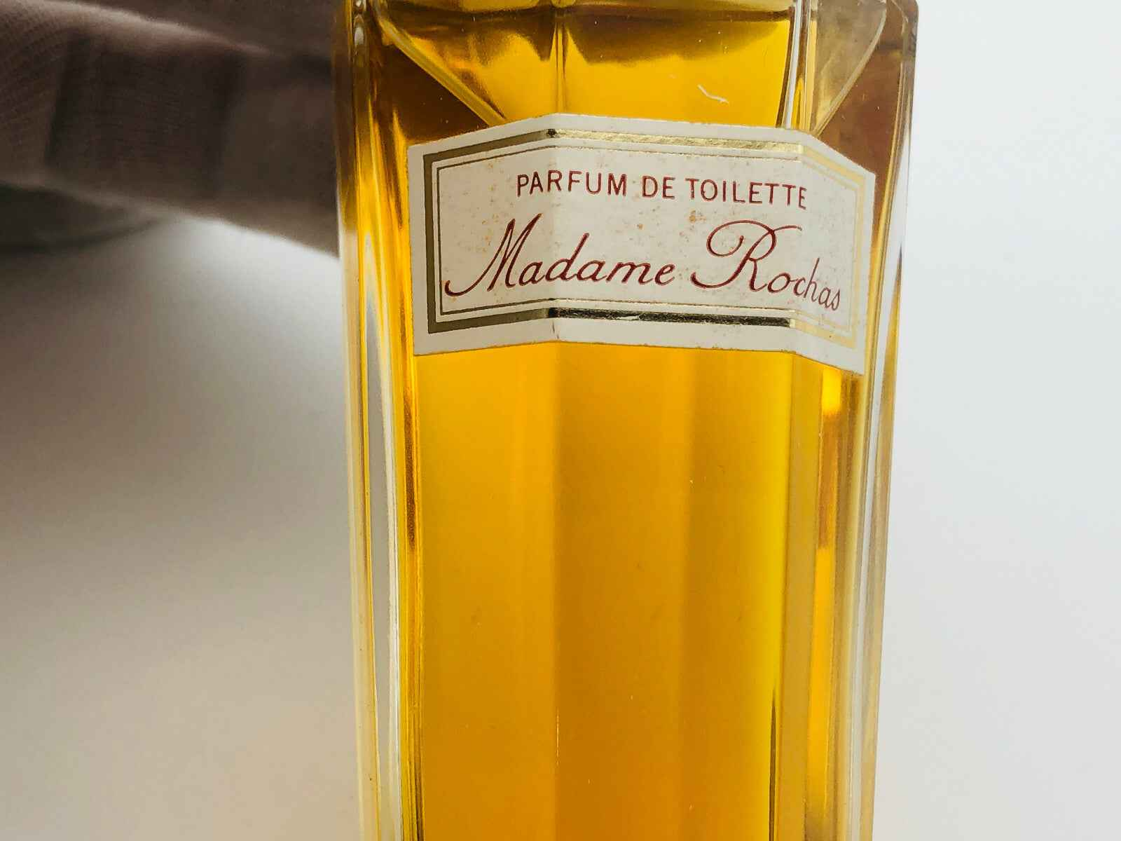 Flacone di profumo vintage Rochas Madame con etichetta Parfum de Toilette e liquido giallo