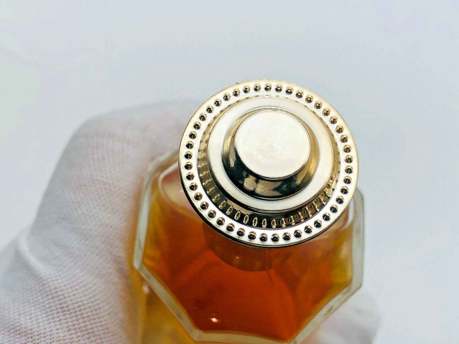 Dettaglio di un flacone di profumo Vintage Rochas Madame con tappo dorato elegante e design sofisticato
