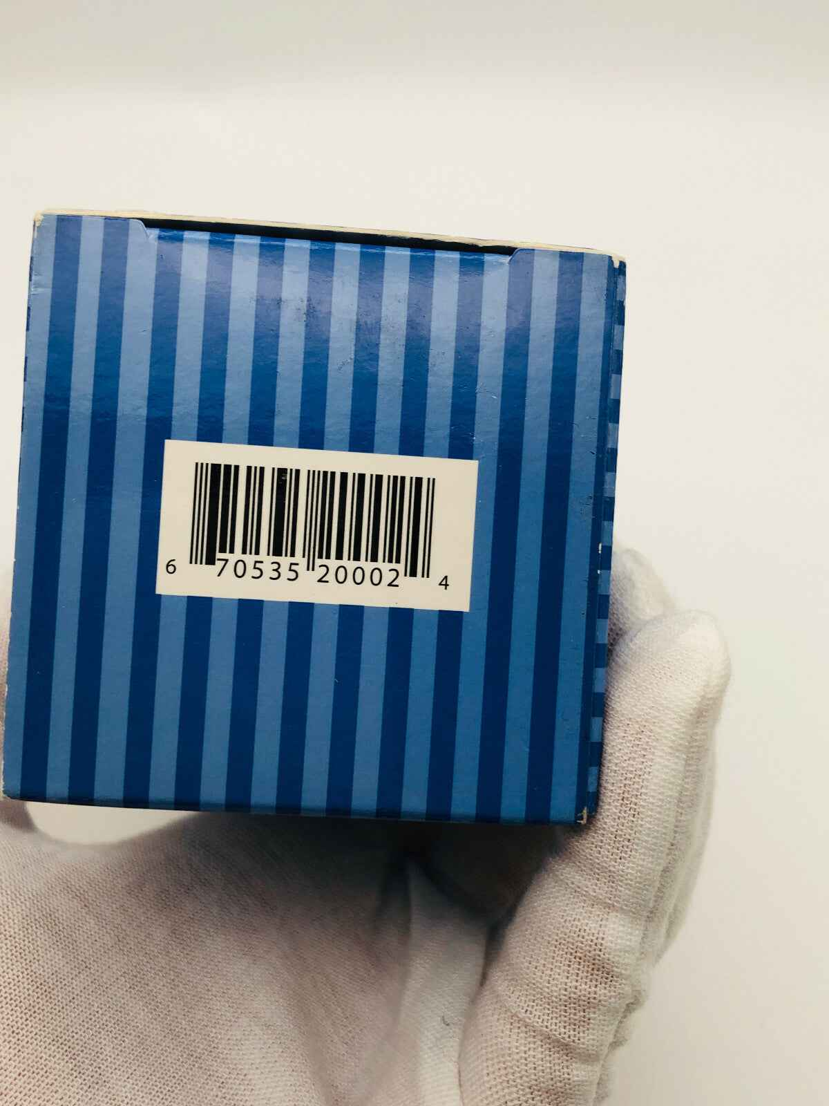 Scatola del prodotto The Art Of Shaving con righe blu e codice a barre
