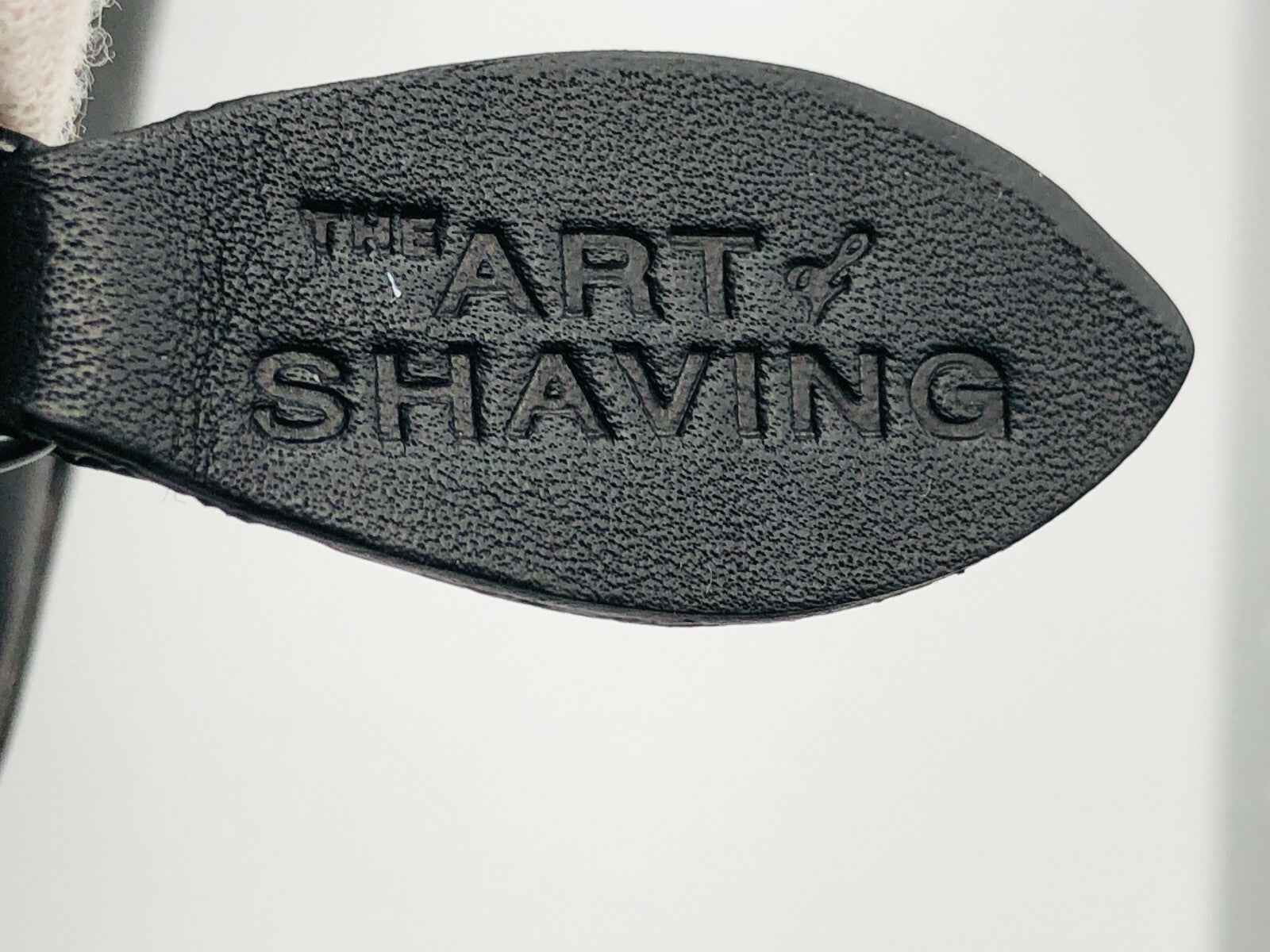 Dettaglio della suola con il marchio The Art Of Shaving su un kit da viaggio