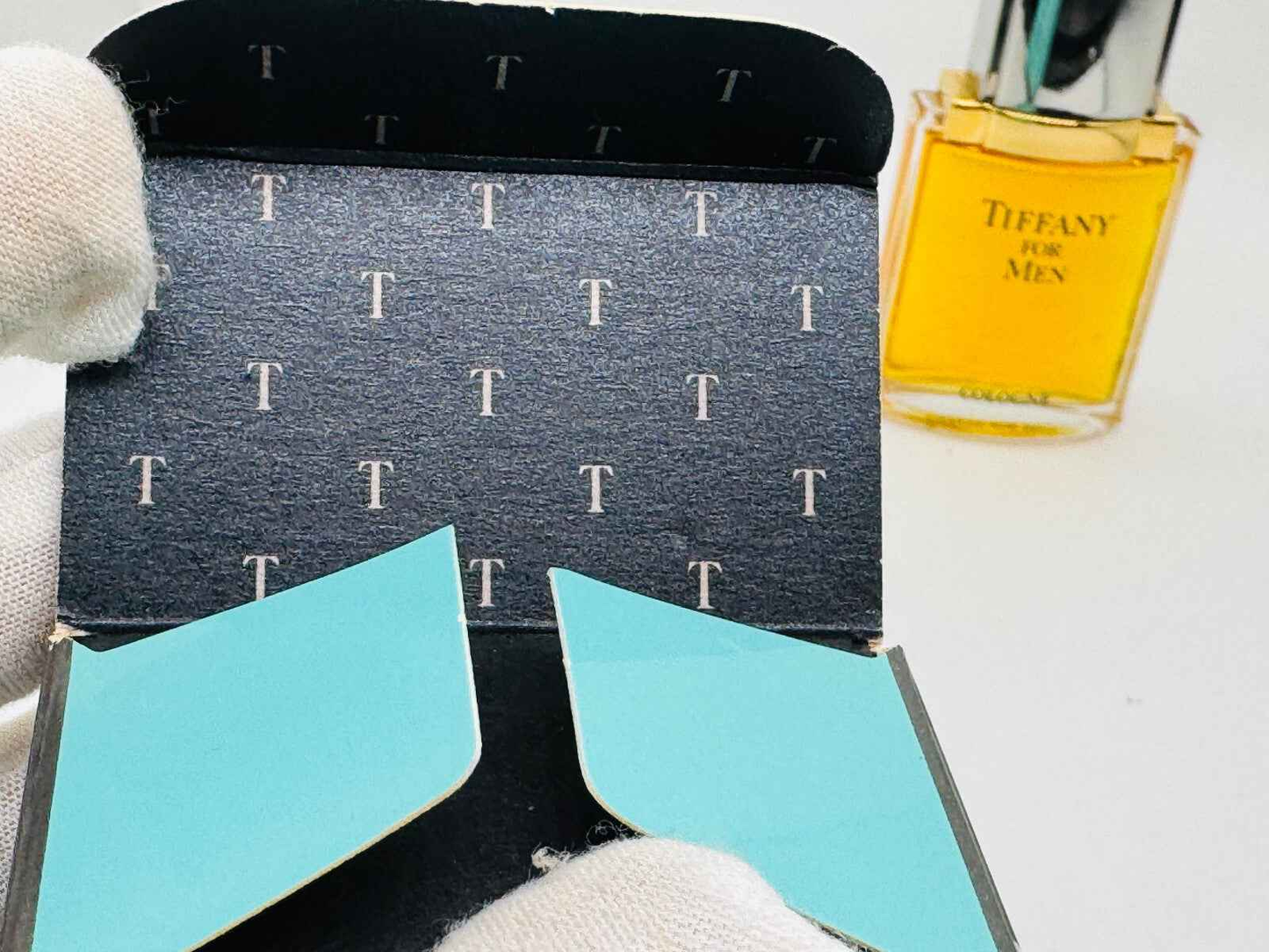 Scatola di Profumo Tiffany For Men Vintage con dettagli blu e flacone di profumo sullo sfondo