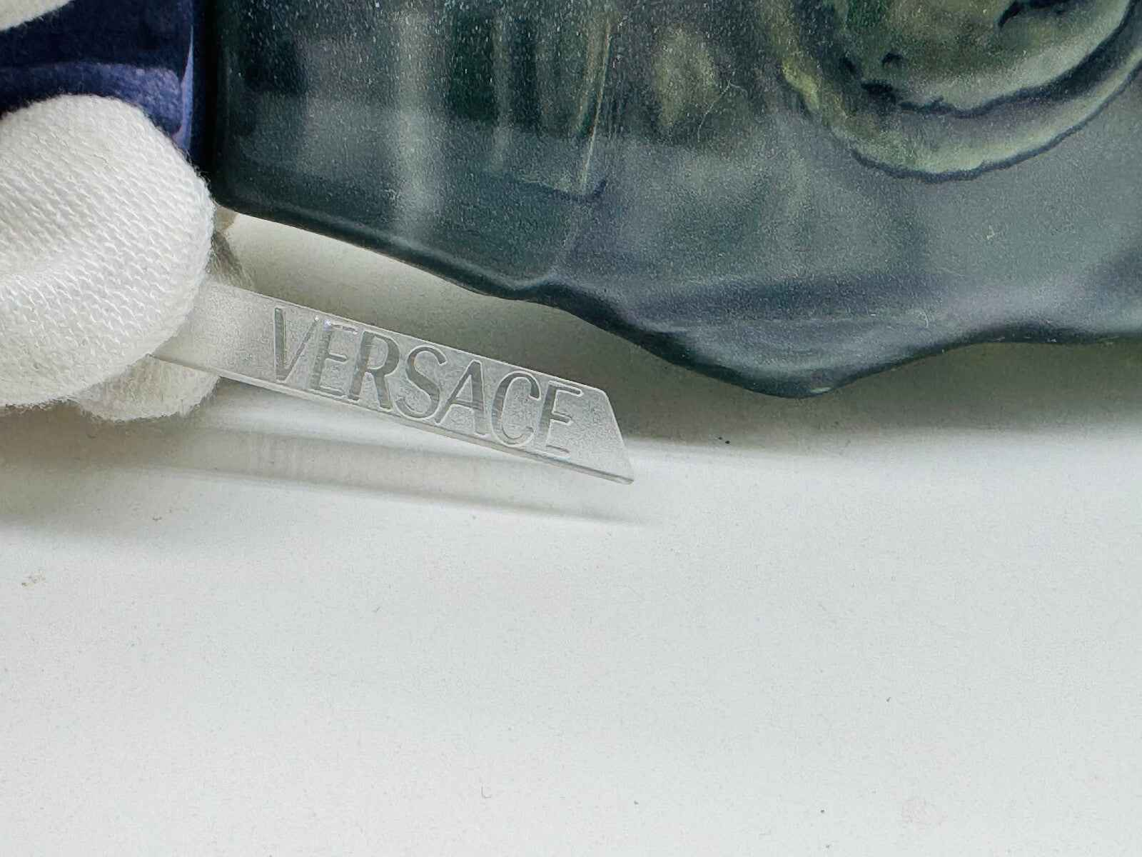 Etichetta Versace su denim vintage con dettagli metallici, perfetti per uno stile unico