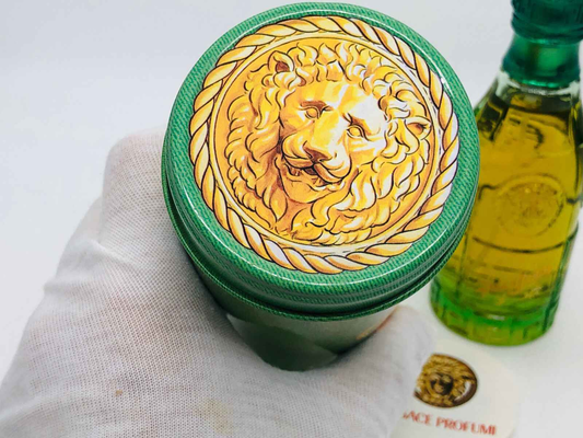 Tappo del profumo Versace Green Jeans con design leone dorato e bottiglia verde sullo sfondo