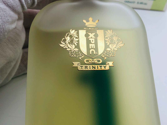 Bottiglia di Profumo Xpec Trinity con eleganti dettagli dorati e design moderno